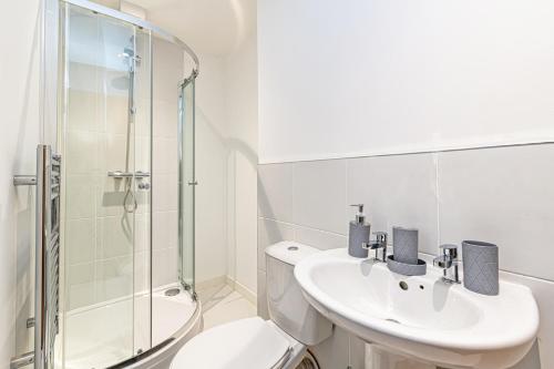 Baño blanco con aseo y lavamanos en Winckley House Serviced Apartments in Preston, en Preston