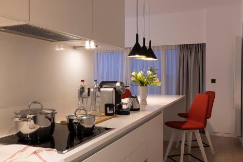 a kitchen with a stove and a red chair at L-Avenue in Brussels