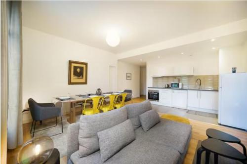 un soggiorno con divano e tavolo con sedie gialle di Magnifique Appartement T4 90 M2 très bien situé 2 min Vieux port et Gare St Charles a Marsiglia