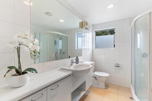 a white bathroom with a sink and a toilet at Spacious relaxing home in Queenstown
