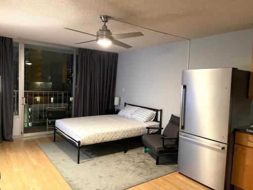 a bedroom with a bed and a refrigerator at Marine Surf in Honolulu