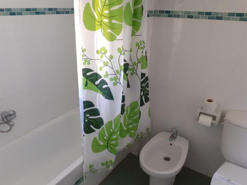 a bathroom with a toilet and a shower curtain with leaves at Hotel Clibomar Jamaica in Gandía