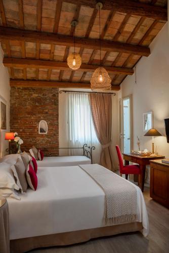 a bedroom with a large white bed and a desk at Locanda I Girasoli in Misano Adriatico