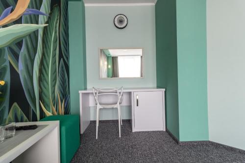 a desk with a chair in a room with a mirror at Art Hotel Palma in Lviv