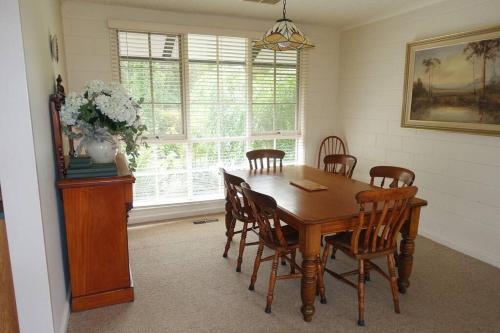 a dining room with a wooden table and chairs at Mon Desir in Chum Creek