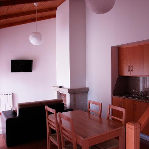 uma cozinha e sala de jantar com uma mesa de madeira e cadeiras em Bungalows - Serra do Gerês em Campo do Gerês