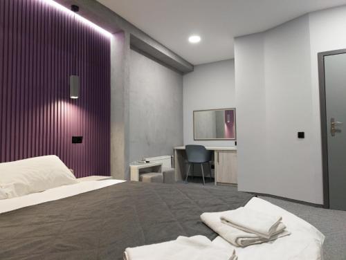 a bedroom with a bed with a purple wall at Art Hotel Palma in Lviv