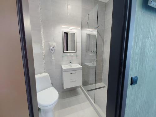 a white bathroom with a toilet and a shower at Art Hotel Palma in Lviv