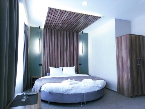a bedroom with a large bed with a wooden headboard at Art Hotel Palma in Lviv