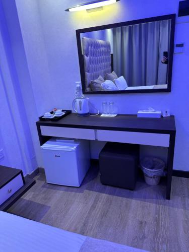a bathroom with a black vanity with a large mirror at Frangiorgio Hotel in Larnaka