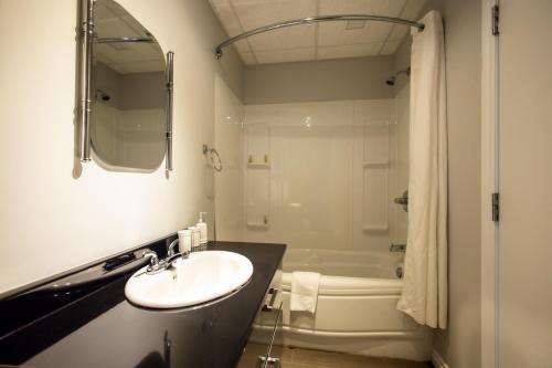 a bathroom with a sink and a bath tub at Le Chic-Urbain in Rouyn