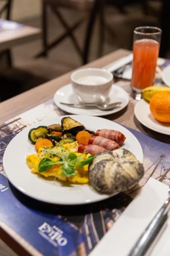 a plate of food with sausage and vegetables on a table at Estilo Fashion Hotel Budapest in Budapest