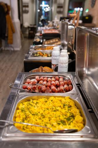 a buffet line of food with eggs and other foods at Estilo Fashion Hotel Budapest in Budapest