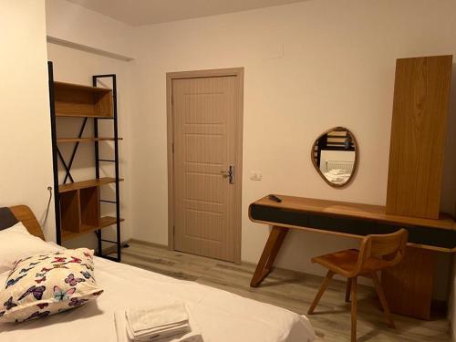 a bedroom with a desk and a bed and a mirror at Coca Apart Mountain View in Sinaia