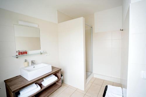 ein weißes Bad mit einem Waschbecken und einer Dusche in der Unterkunft Wallseerhof in Wallsee