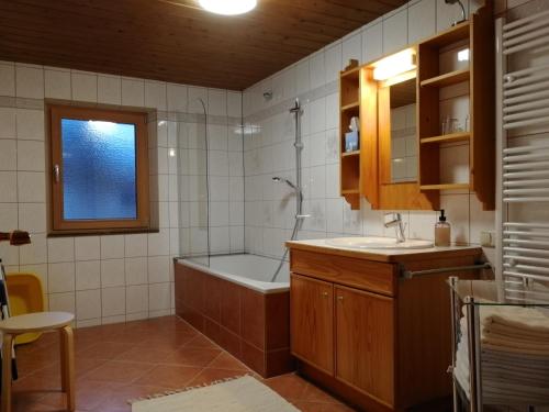 La salle de bains est pourvue d'une baignoire, d'une douche et d'un lavabo. dans l'établissement Ferienwohnung Ehrensberger, à Brixen im Thale