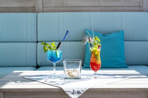 a table with two vases and two glasses on it at Hotel Le Soleil in Lido di Jesolo