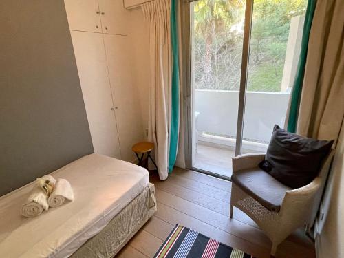 une chambre avec un lit, une chaise et une fenêtre dans l'établissement La Mirandole by Connexion, à Vallauris