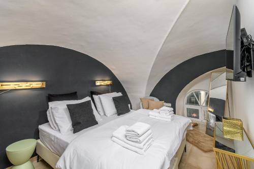 a bedroom with a large bed with white sheets at Nina Luxury Apartment in Jerusalem