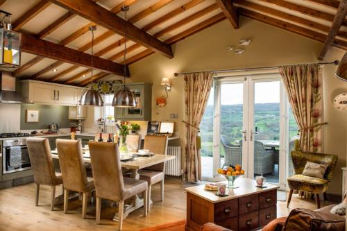 a kitchen and living room with a table and chairs at Unique Retreats in Sleights