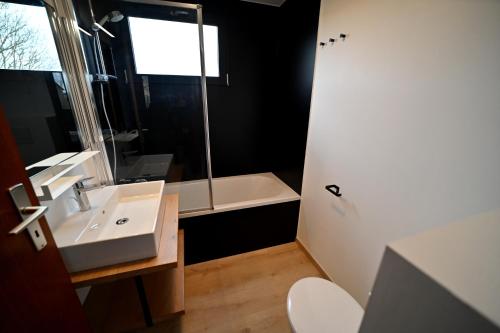 a bathroom with a sink and a bath tub at La Tanière in Noiseux