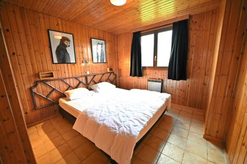 sypialnia z łóżkiem w drewnianym pokoju w obiekcie La Tanière w mieście Noiseux