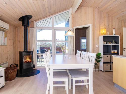 a dining room with a white table and a fireplace at 6 person holiday home in Hemmet in Falen