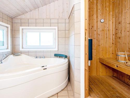 a bathroom with a white tub and a window at 6 person holiday home in Hemmet in Falen