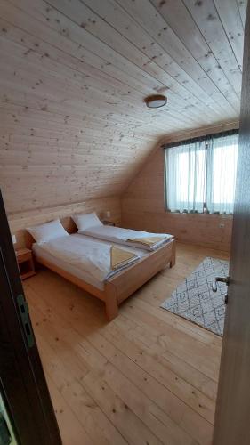 een slaapkamer met een bed in een houten kamer bij Planinska kuća Jabuka in Prijepolje