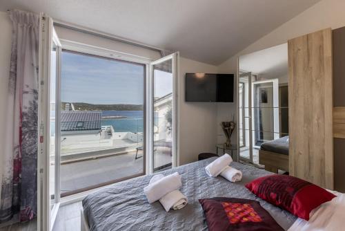 sypialnia z łóżkiem i widokiem na ocean w obiekcie Villa Desire with private pool and sea view w mieście Sevid