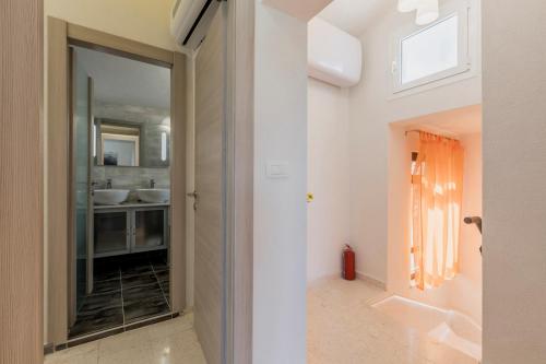 Łazienka z dużymi szklanymi drzwiami prowadzącymi do umywalki w obiekcie Villa Desire with private pool and sea view w mieście Sevid