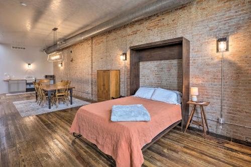 a bedroom with a bed and a brick wall at Downtown Cherokee Iowa Vacation Rental in Cherokee