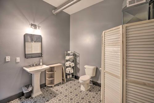 a bathroom with a sink and a toilet and a mirror at Downtown Cherokee Iowa Vacation Rental in Cherokee