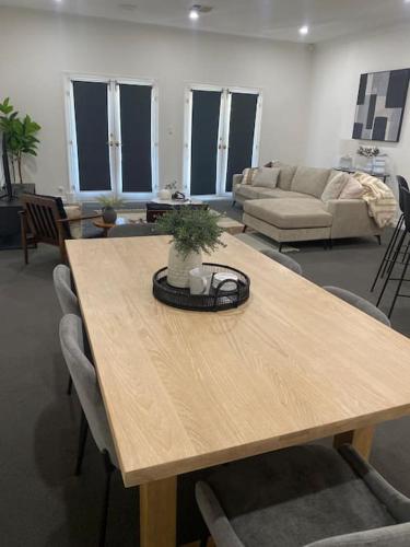 a living room with a wooden table and a couch at Location location: Melbourne street views in Adelaide