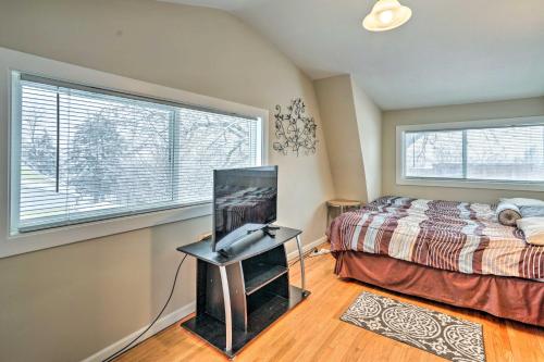 1 dormitorio con 1 cama y TV de pantalla plana en Minneapolis Home Near Medicine Lake and Trails!, en Minneapolis