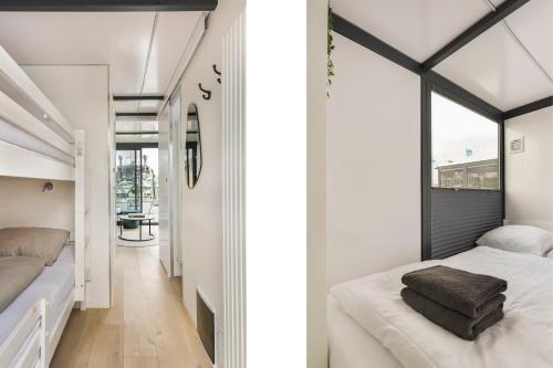 a bedroom with two beds and a window at Cosy tiny houseboats near beach and restaurants by Weltevreden Experience in Zeewolde