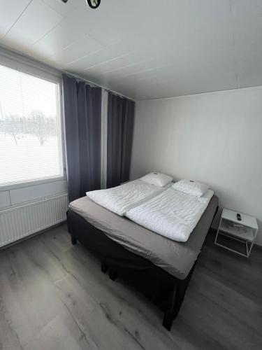 a bedroom with a bed in a room with a window at SEO Motel Alavieska in Alavieska