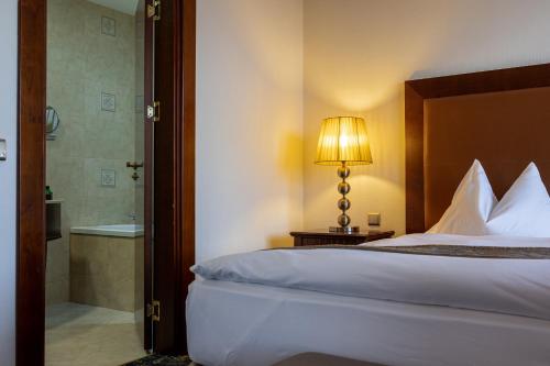 a hotel room with a bed and a bathroom at Primoretz Grand Hotel & Spa in Burgas City