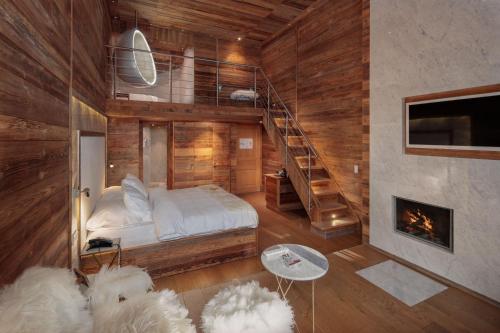 um quarto com um beliche e uma lareira em Hostellerie du Pas de l'Ours "Relais et Châteaux" em Crans-Montana