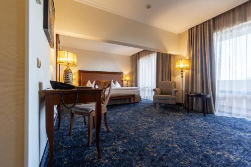 a hotel room with a desk and a bed at Primoretz Grand Hotel & Spa in Burgas City