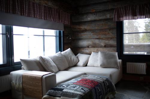 sala de estar con sofá blanco y 2 ventanas en Villa Sukka en Kuusamo