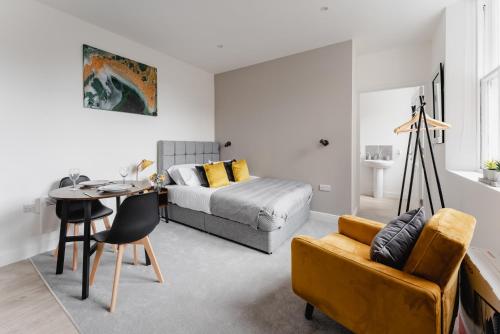 a bedroom with a bed and a table and a couch at Prescott Court Serviced Apartments in Halifax