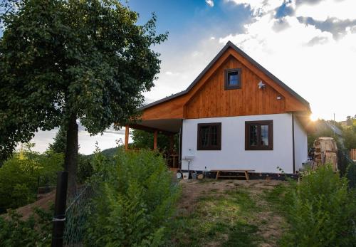 a small white house with a wooden roof at Libling Hruštička in Banská Štiavnica