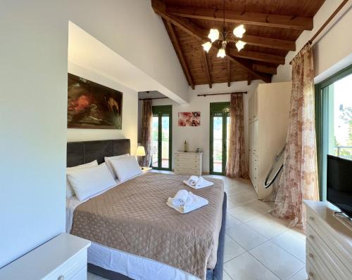 a bedroom with a bed and a flat screen tv at Villa Atlantis in Katelios