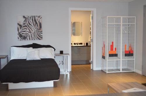a bedroom with a bed and a kitchen in the background at Le Chic-Urbain in Rouyn