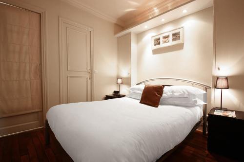 - une chambre avec un grand lit blanc et des oreillers blancs dans l'établissement bridgestreet ST GERMAIN, à Paris