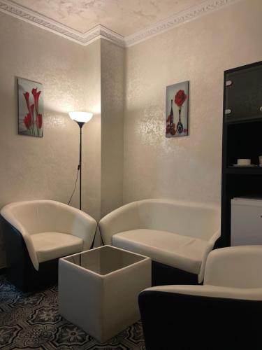 a living room with two white couches and a table at The Castle Hotel in Amman