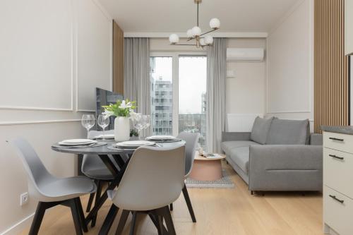 eine Küche und ein Wohnzimmer mit einem Tisch und Stühlen in der Unterkunft Wola Spacious Flat with Air Conditioning & Balcony by Renters in Warschau