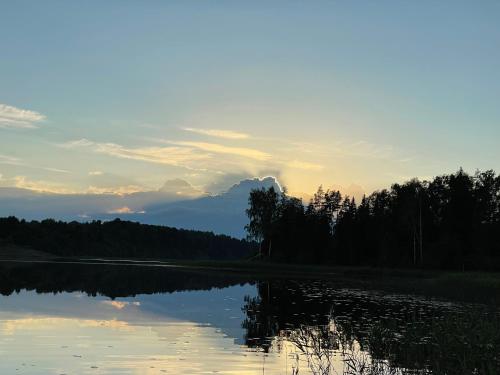 a view of a lake with a mountain in the background at Ieviņi atpūtas vieta in Bānūži
