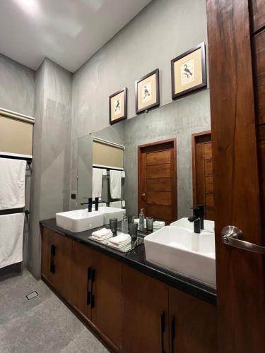Hotel Dumaguete في دوماغيتي: حمام به مغسلتين ومرآة كبيرة